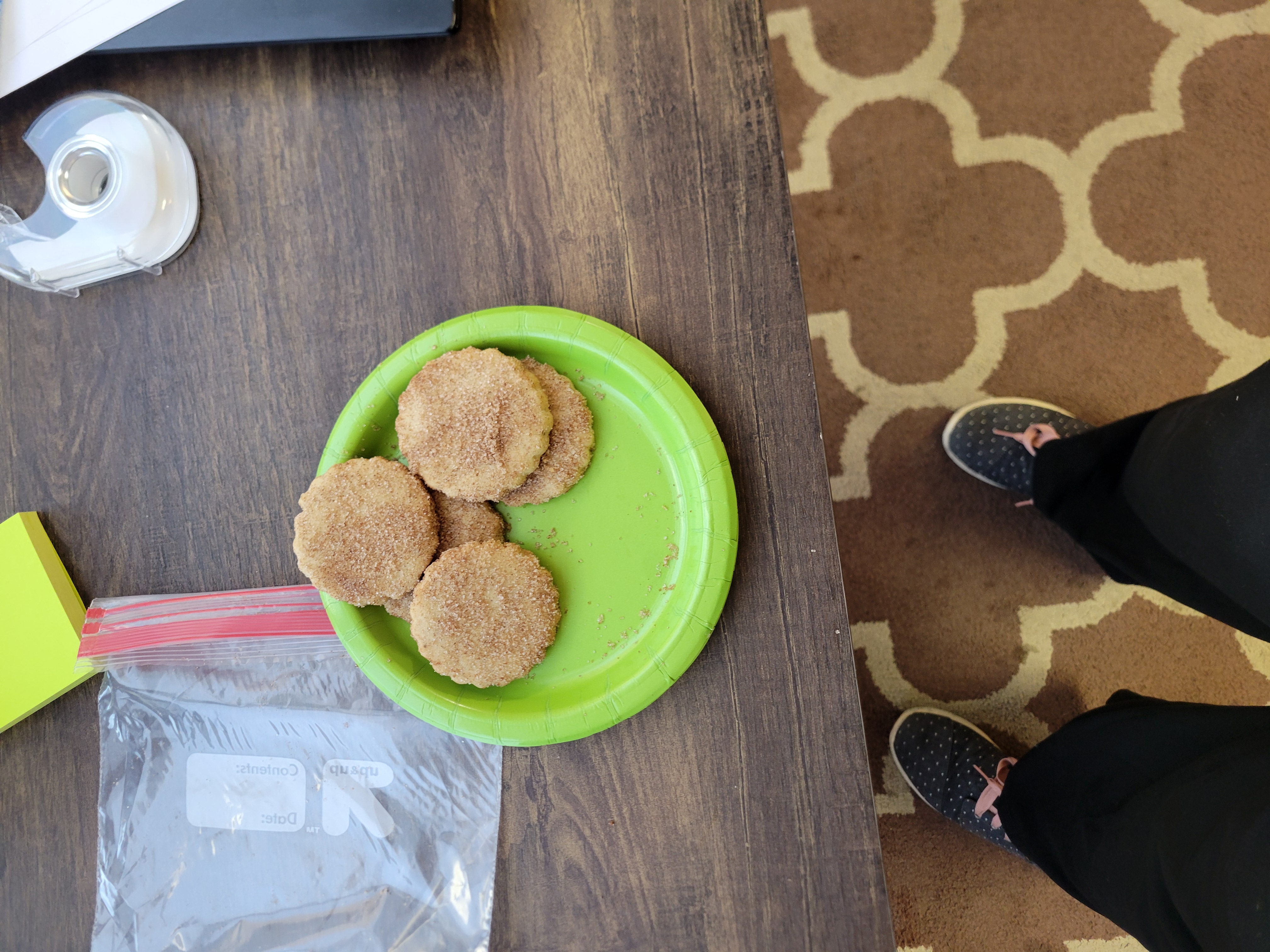 3 Biscochitos on a paper plate with shoes in frame.